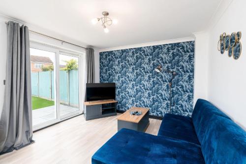 een woonkamer met een blauwe bank en een tv bij Driveway Parking Garden Large House Good Location 