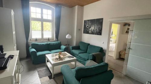 una sala de estar con sofás azules y una mesa. en Alte Post - Erdgeschoß, en Gützkow
