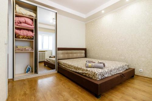 a bedroom with a bed and a large mirror at Kvartirkoff na Polku Azov 32b in Kyiv