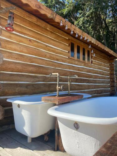 bañera frente a una pared de madera en Cabana do lenhador, en Espírito Santo do Pinhal