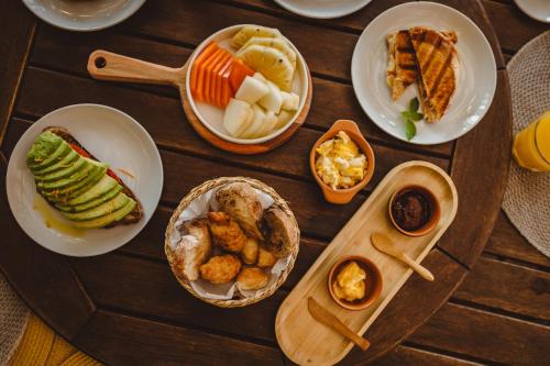 una mesa de madera con platos de comida. en Pousada Moana en Fernando de Noronha