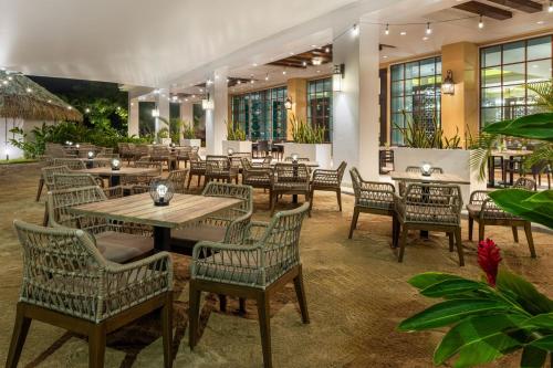 プラヤ・ボニータ・ビリャヘにあるザ ウェスティン プラヤ ボニータ パナマのテーブルと椅子、植物のあるレストラン