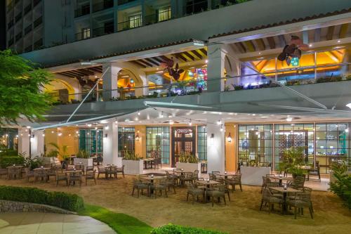 a restaurant with tables and chairs in front of a building at The Westin Playa Bonita Panama in Playa Bonita Village