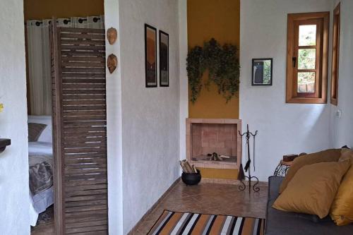 a living room with a couch and a fireplace at Orobó Kaá - entre a floresta e a vida no campo in Monteiro Lobato