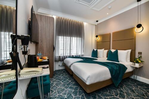 a hotel room with a large bed and a camera at Queens Park Premier London Hyde Park in London