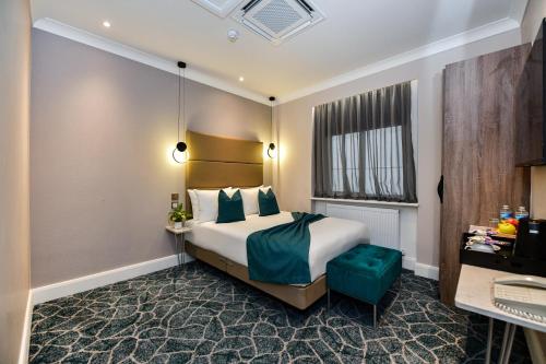 a hotel room with a bed and a window at Queens Park Premier London Hyde Park in London