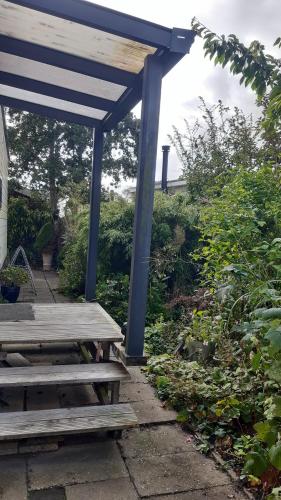 a wooden picnic table under a blue shelter at Kitty's Place Warmond in Warmond
