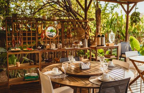 a wooden table and chairs in a garden at Pousada Moana in Fernando de Noronha