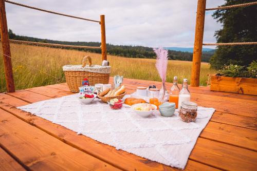 stół piknikowy z jedzeniem i napojami na stole w obiekcie Glamping U hranic w mieście Červená Voda