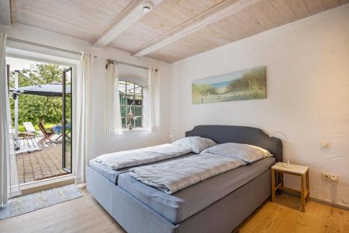 a bed in a room with a large window at Wohnung 1 Terrassenwohnung in Stockelsdorf