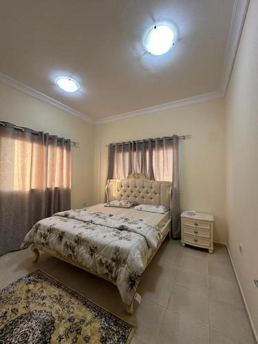 a bedroom with a large bed and two windows at Private Room - Apartment in Al Ḩayrah