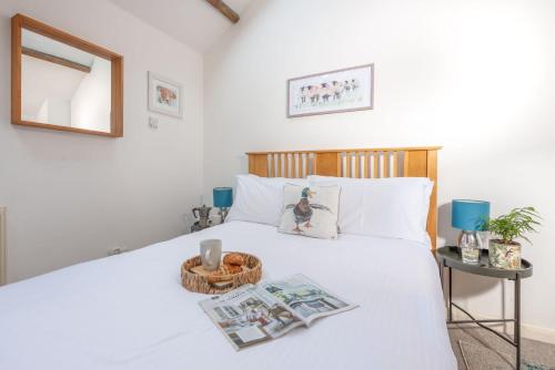 a bedroom with a white bed with a basket on it at Laity Vean Hideaway in Carbis Bay