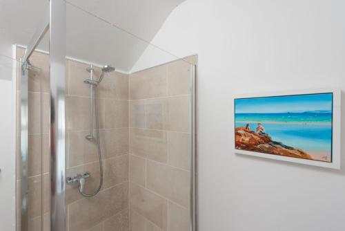 a bathroom with a shower and a tv on the wall at Laity Vean Hideaway in Carbis Bay