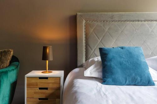 a bed with a blue pillow and a lamp on a night stand at Fantastic studio by the lake with Mountain View in Chamonix-Mont-Blanc