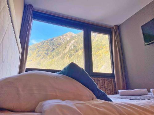 Schlafzimmer mit einem Bett und einem Fenster mit Bergblick in der Unterkunft Fantastic studio by the lake with Mountain View in Chamonix-Mont-Blanc