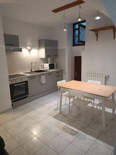 a kitchen with a wooden table and chairs in it at La Maison cévenole in Saint-André-de-Majencoules