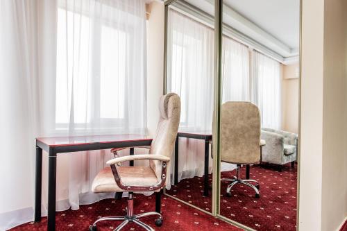 a room with a table and two chairs and a mirror at Star Rent Hotel in Chişinău