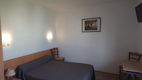 a bedroom with a bed and a picture on the wall at Auberge le Cévenol in La Cavalerie