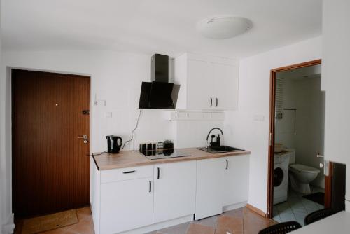 una cocina con armarios blancos y fregadero en Apartament Serce Łodzi, en Łódź