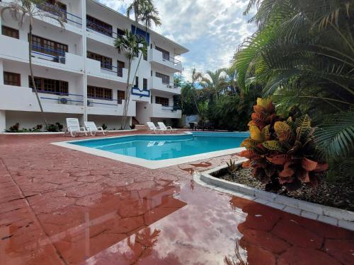 a swimming pool in front of a building at Calypso Beach Hotel by The Urbn House Santo Domingo Airport in Boca Chica