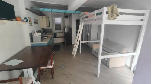 a room with two bunk beds and a desk at Appartamento Vecchia Bottega in Orino