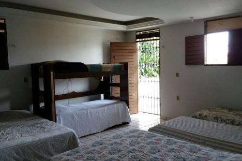 sypialnia z 2 łóżkami piętrowymi i oknem w obiekcie João Pessoa e Cabedelo CASA CAMBOINHA w mieście Cabedelo
