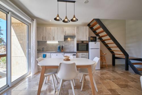 une cuisine avec une table et des chaises ainsi qu'un escalier dans l'établissement La Mottinière, à Saint-Hilaire-du-Rosier
