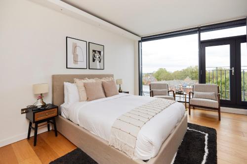 a bedroom with a large bed and a large window at The Shoreditch Escape - Lovely 2BDR Flat with Balcony in London