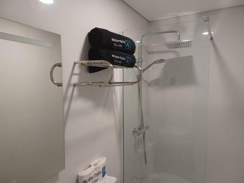 a bathroom with a shower with a book on a rack at Waterfalls Gerês AL in Geres