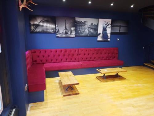 Luxury central Newcastle apartment, sleeps 8 في نيوكاسل أبون تاين: أريكة حمراء في غرفة مع صور على الحائط