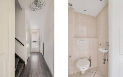 uma casa de banho branca com um WC e um lavatório em Apeldoorn- ruime eengezinswoning met 5 slaapkamers em Apeldoorn