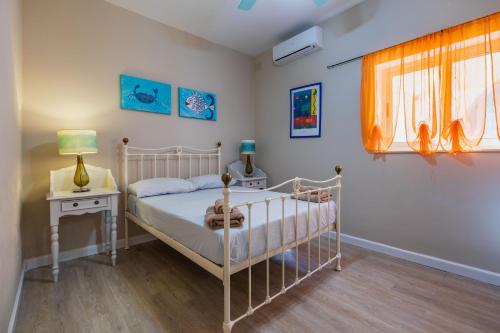 Schlafzimmer mit einem Bett, einem Tisch und einem Fenster in der Unterkunft Villa Palma - Sunset Sea Views with Pool, Jacuzzi, Sauna and Games Room in Mellieħa