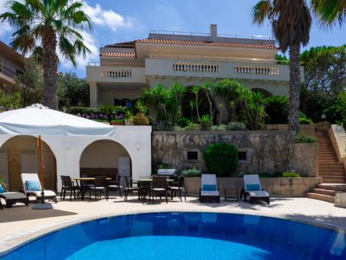 a resort with a swimming pool and a building at Villa Palma - Sunset Sea Views with Pool, Jacuzzi, Sauna and Games Room in Mellieħa