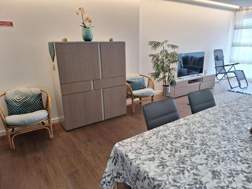 a living room with a table and chairs and a tv at Coliseum Residence in Ponta Delgada