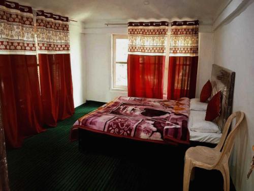a bedroom with red curtains and a bed and a chair at OYO Home Homestay Manzoor Dedard in Pahalgām