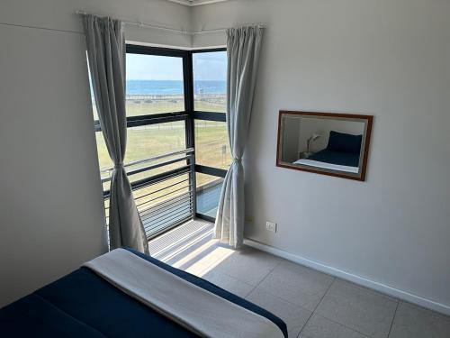 sypialnia z łóżkiem i dużym oknem w obiekcie Point Beach #Accommodation - Durban Beach & Waterfront Canals EPIC VIEWS w mieście Durban