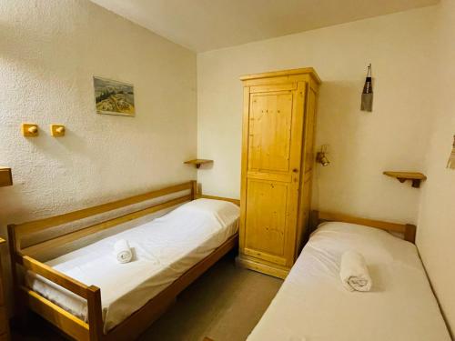 - une chambre avec deux lits et une armoire dans l'établissement Charmant 2 pièces à Méribel, proche des pistes et commerces, avec terrasse ouest, pour 4 personnes - FR-1-411-144, à Les Allues