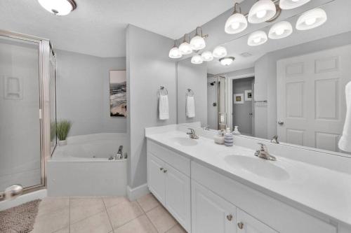 une salle de bain avec deux lavabos et un grand miroir dans l'établissement Beachfront Condo #607 at Majestic Beach Resort, à Panama City Beach