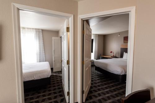 GahannaにあるTownePlace Suites Columbus Airport Gahannaのベッド2台と鏡が備わるホテルルームです。
