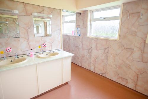 baño con 2 lavabos y espejo grande en Kirkwall Youth Hostel, en Kirkwall