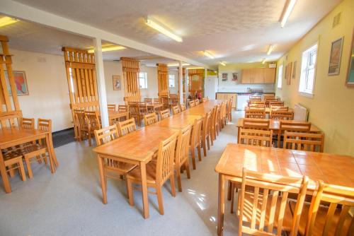 a classroom with wooden tables and wooden chairs at Kirkwall Youth Hostel in Kirkwall