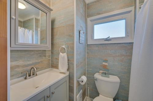 a bathroom with a toilet and a sink and a window at Cozy Hampton Vacation Rental, Walk to Beach! in Hampton