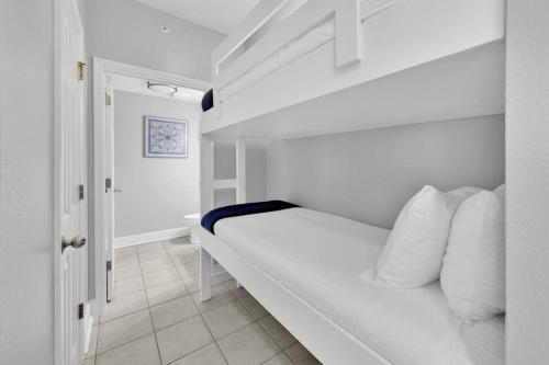 a white bedroom with a bed with white pillows at Beachfront Condo #608 at Majestic Beach Resort in Panama City Beach