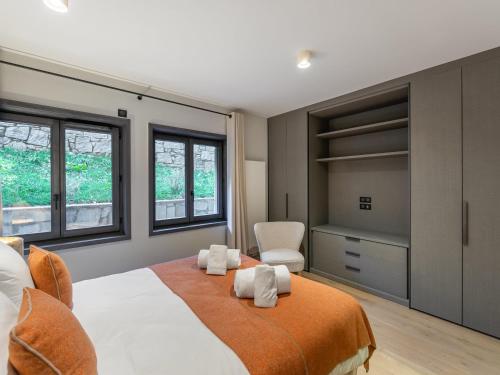 une chambre avec un grand lit et deux fenêtres dans l'établissement Duplex Neuf Près des Pistes avec Cheminée, Parking et Wifi Inclus - FR-1-562-72, à Courchevel