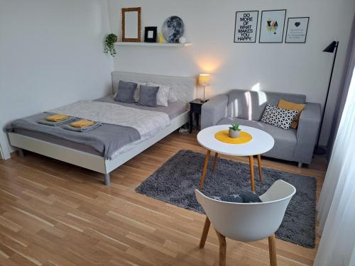 a bedroom with a bed and a table and a chair at Adam apartmán in Košice
