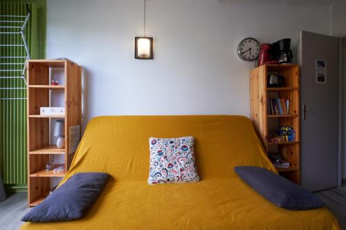 a bedroom with a yellow bed with a pillow on it at Studio Villard De Lans in Villard-de-Lans