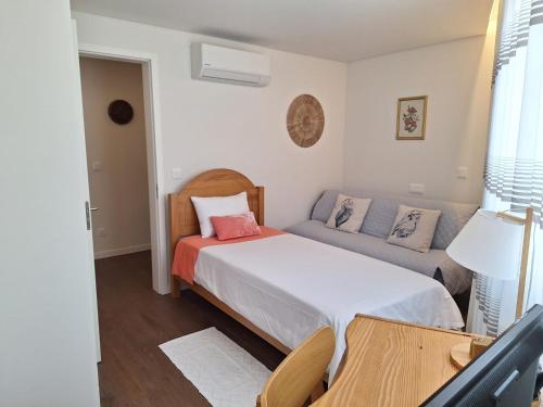 a small bedroom with a bed and a couch at Coliseum Residence in Ponta Delgada