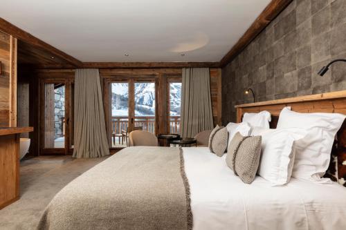 a bedroom with a large bed with white pillows at M Lodge & Spa in Saint-Martin-de-Belleville