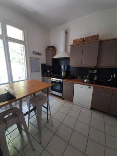 une cuisine avec une table en bois et une table et des chaises dans l'établissement Tours - Grand appartement - centre ville parking gratuit, à Tours