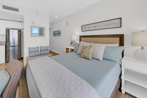 a bedroom with a large bed and a chair at Beachfront Studio #1112 at Majestic in Panama City Beach